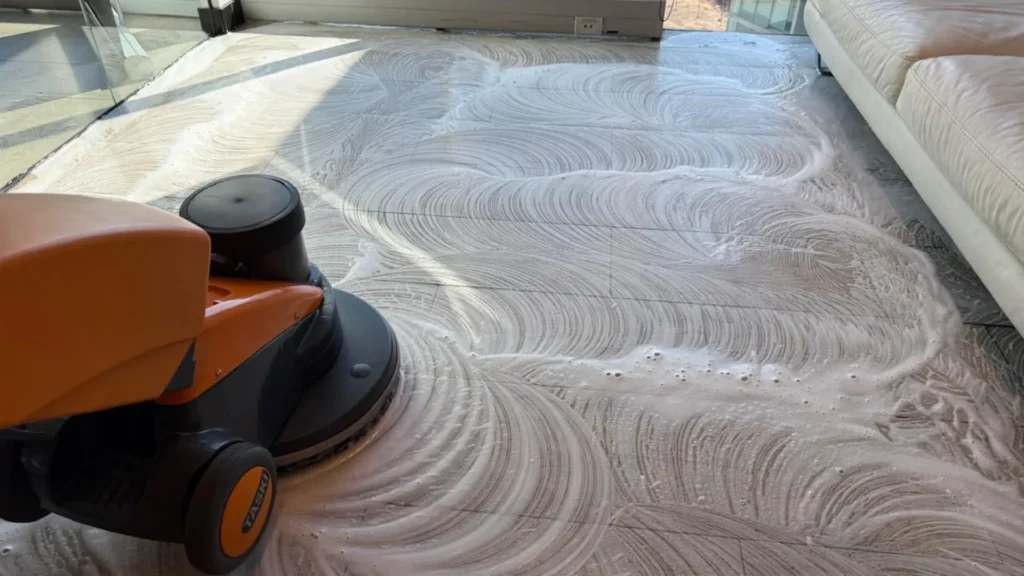 Proceso técnico de lavado con tecnología TASKI y espuma activa para la limpieza profunda de pisos de oficina.